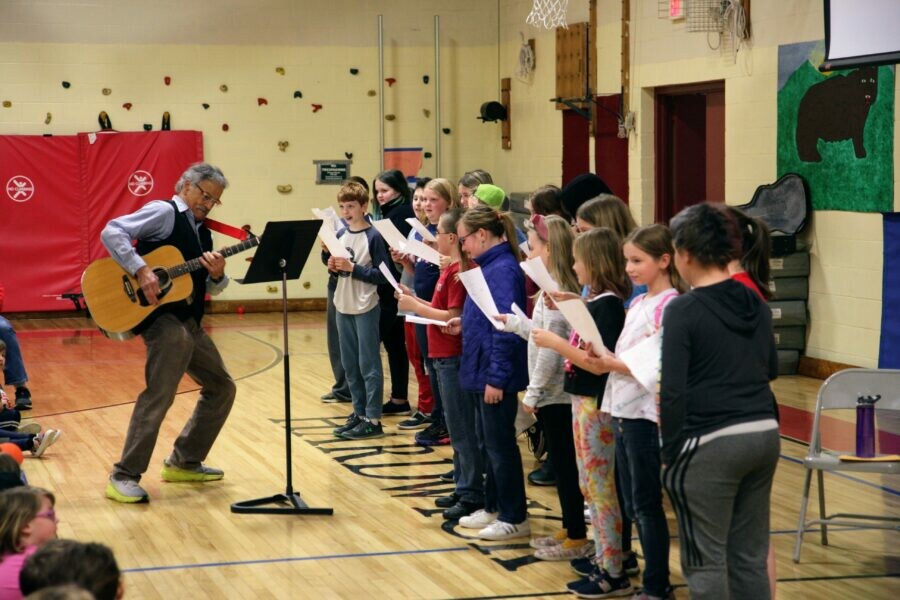 Jon Gailmor, CLiF presenter, leading elementary students in a musical reading program at a school assembly.