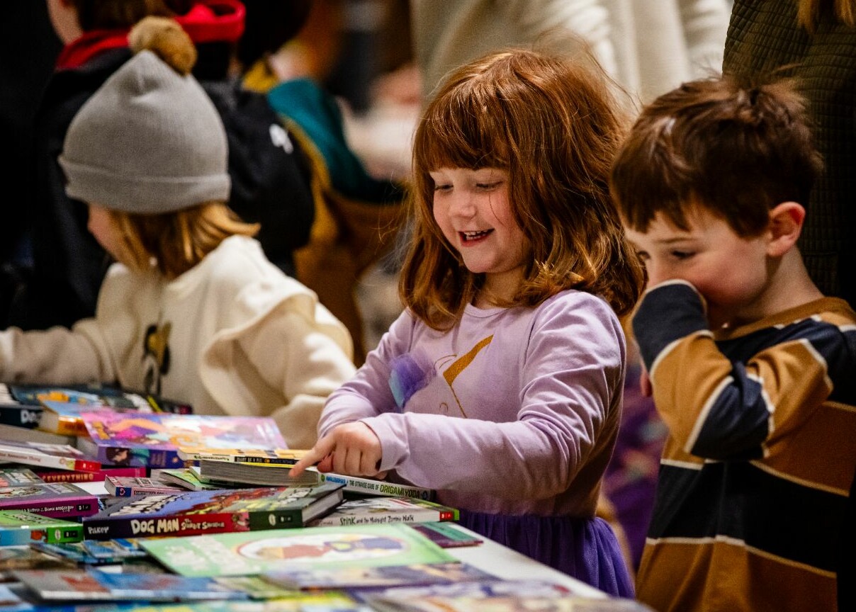 Two girls choose books from a display