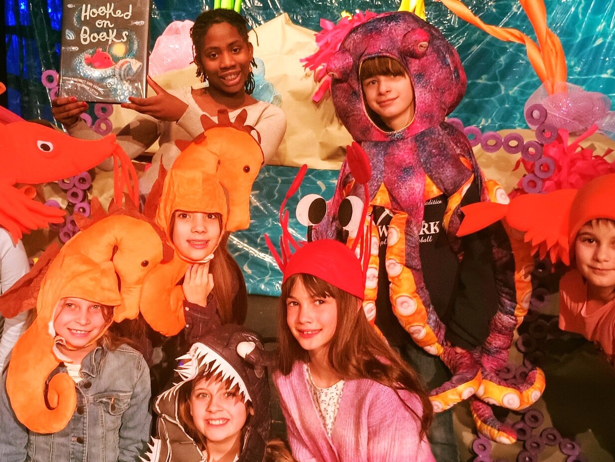 Children wear colorful costumes at a literacy theater camp
