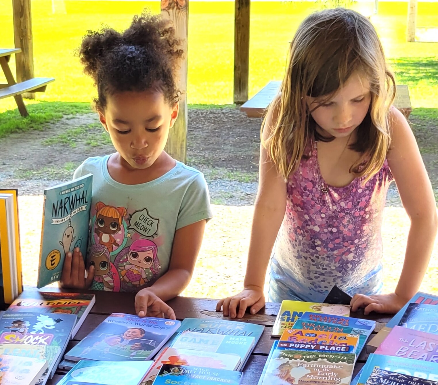 Two girls choose books from a display