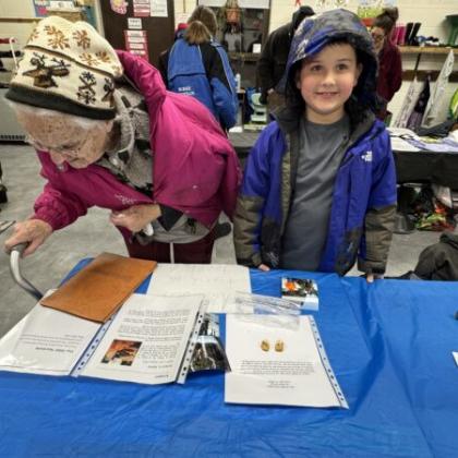 Kids exploring books and worksheets at a table during a literacy or school activity.