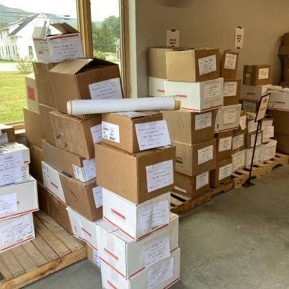 Organized pallets of cardboard shipping boxes with printed labels prepared for shipment in a warehouse.